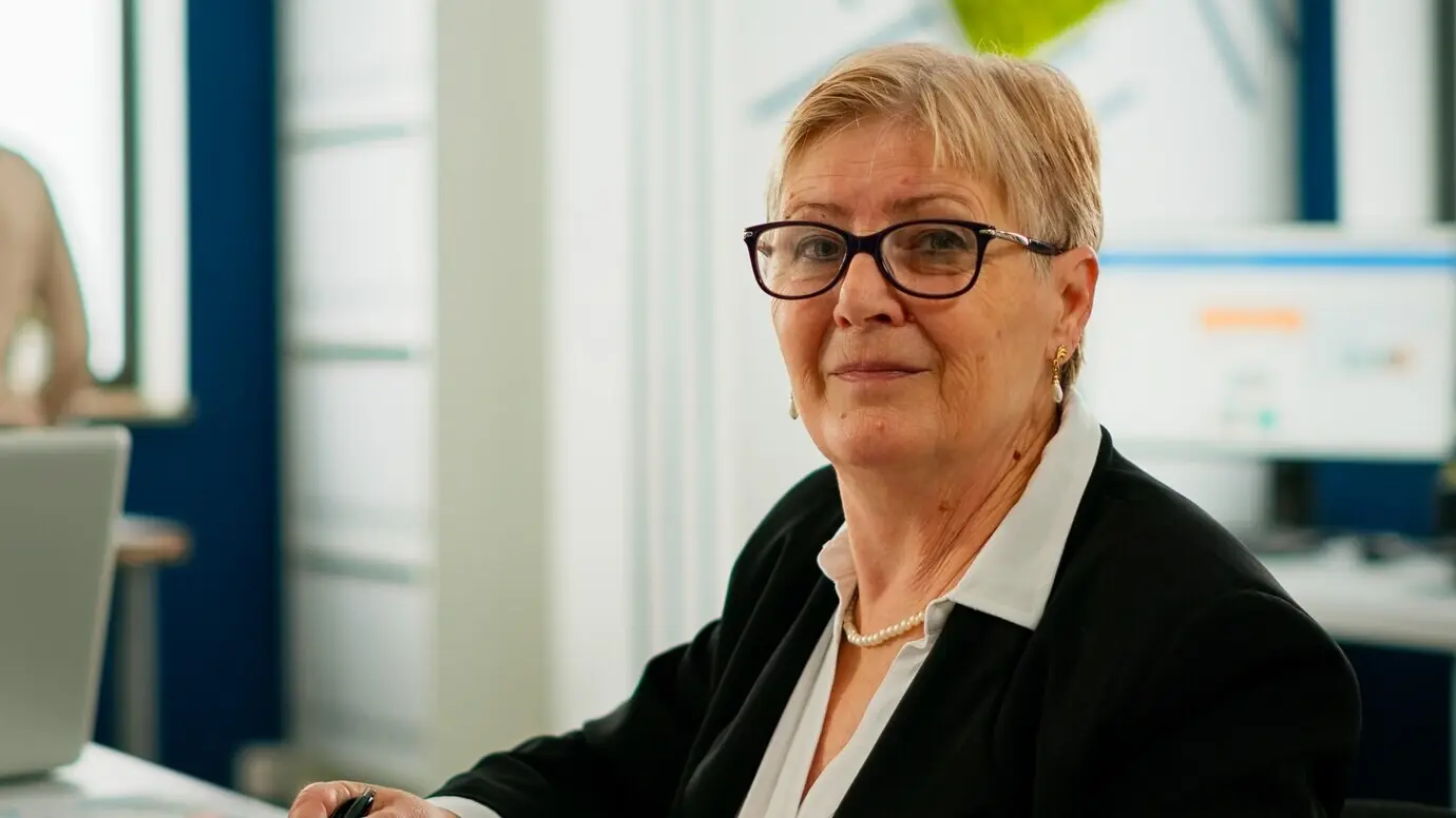 Porträt einer älteren Geschäftsfrau, die in einem Brainstorming-Raum sitzt, in die Kamera blickt und sich auf ein Treffen mit Partnern vorbereitet. Managerin in einem professionellen Finanz-Start-up, bereit für die Konferenz.